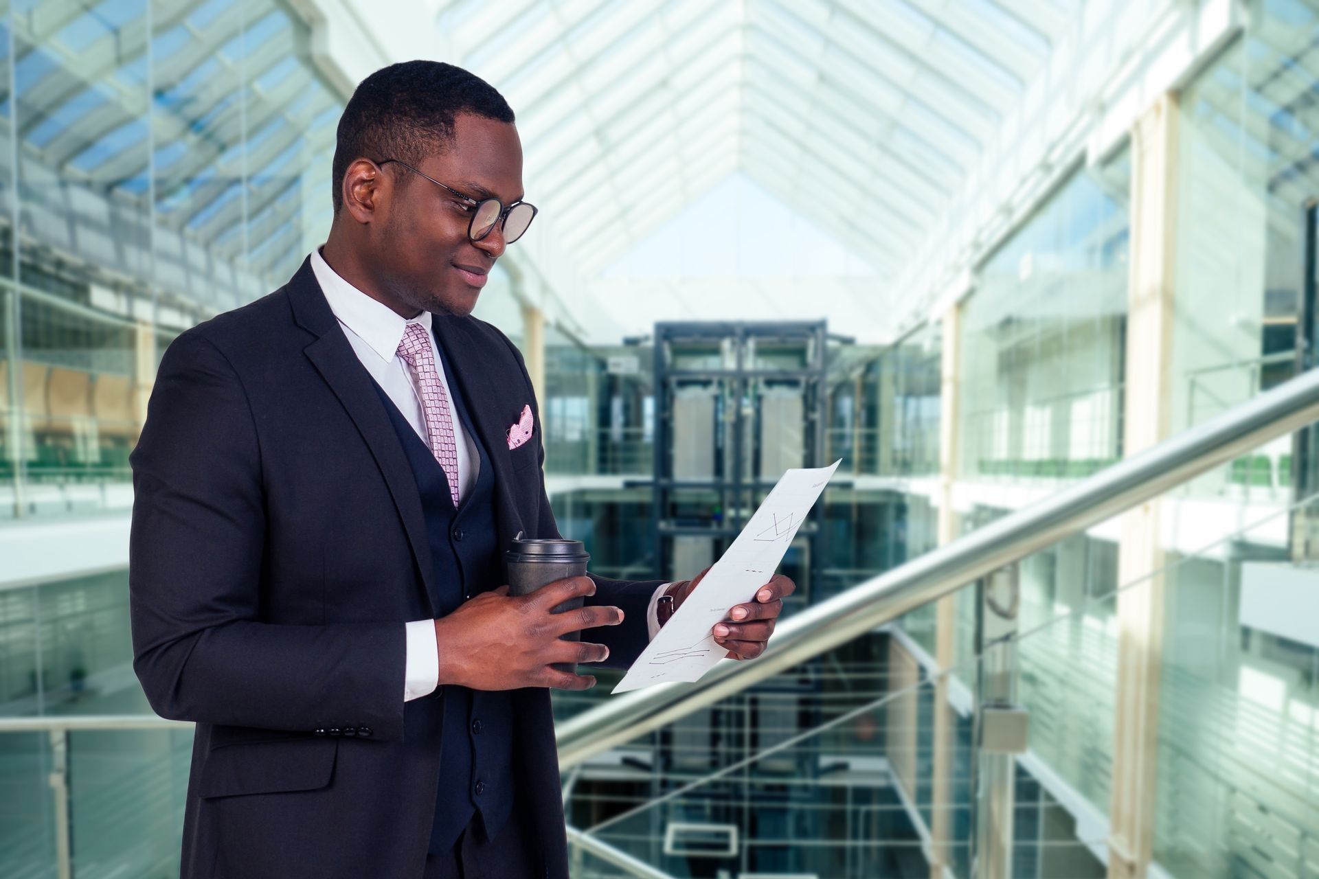 beautiful and well dressed afro american man in a stylish business suit and glasses indoors background of the business center